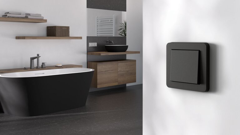 Modernes Badezimmer mit schwarzem Lichtschalter.